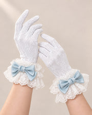 Both hands wearing lined white lace gloves with ice blue Christmas Bridal bow cuffs