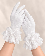 Both hands wearing lined white lace gloves with white Christmas Bridal bow cuffs